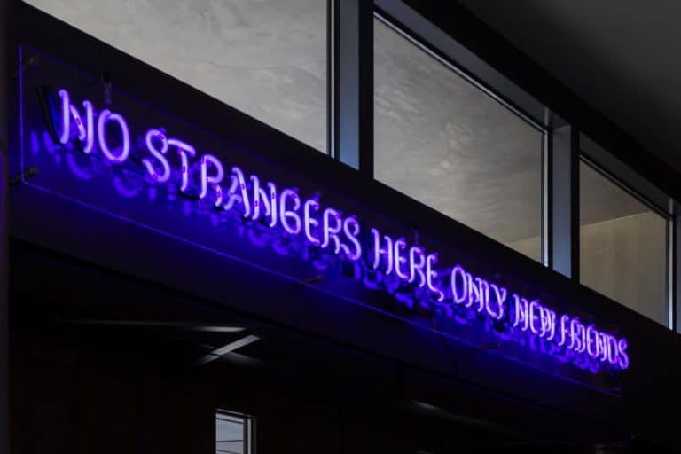 Sign at Park James Hotel that reads "No strangers here, only new friends."